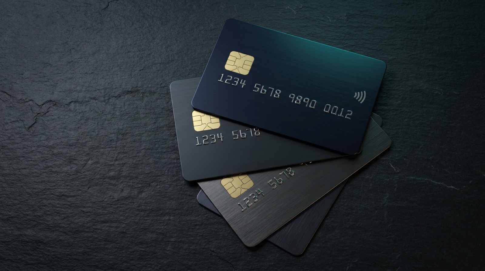 A fan of premium credit cards on a dark desk